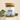 Megan & Co. Chest Re-Leaf tea in a glass apothecary jar with a bamboo lid, surrounded by eucalyptus leaves at the bottom with a soft, blurry background.