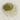 A small mound of dried, sage-green eucalyptus leaf pieces, scattered across a light grey veined marble surface.