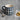 A navy blue stoneware mug with a white debossed celestial moon pattern, shown on a grey wood-textured surface next to two shortbread cookies on parchment paper and a silver spoon.