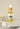A small bottle of Happy Ear Herbal Oil with a dropper, placed on a soft surface alongside decorative flowers.