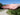 Hand holding a small amount of water with a blurred background of a path and trees