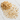 A 28g scattering of dried, light-tan ashwagandha root segments on a white marble surface.