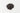 A small, rounded mound of tiny, dark purple-to-black dried elderberries centered on a clean white surface.