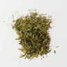 A pile of dried alfalfa leaves on a white background.