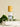A clear spray bottle labeled 'AWAKE' with a wooden cap, surrounded by green leaves on a white marble surface.
