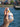 A hand misting the Boji Bliss spritzer, showing a fine spray of essential oil against a scenic, blurred background of a Ferris wheel and the sea.
