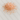 A loose mound of coarse pink Himalayan salt crystals, featuring various shades of peach and salmon pink, scattered on a white marble surface with light grey veining.