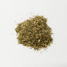 A small, neat mound of dried California poppy aerial parts, including chopped green stems and leaves, centered on a plain white surface.