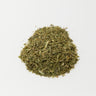 A small, rounded mound of dried green chickweed leaves and finely chopped stems centered on a clean white surface.