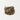 A small, textured mound of dried, dark brown and tan comfrey root pieces, cut and sifted, centered on a plain white surface.