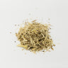 A small, textured mound of dried eleuthero root pieces, featuring a mix of pale straw-colored woody fragments and thin, fibrous shreds, centered on a clean white surface.