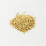 A small, centered mound of dried ginger root pieces, featuring a pale, creamy-yellow color and a fibrous, woody texture on a plain white surface.