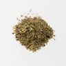A small mound of dried ginkgo leaf pieces, featuring a variety of olive and muted green tones, on a clean white surface.