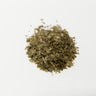 A small mound of dried Horny Goat Weed leaves, featuring a textured mix of muted olive-green fragments and thin, pale brown stem pieces on a plain white surface.