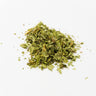 A loose pile of dried lemon verbena leaves, appearing as vibrant green, slightly crushed herbal fragments with small stem pieces, staged on a clean white background.