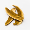 Three long, curved slices of dried reishi mushroom, showing a woody, tan-colored porous underside and dark, firm outer edges, staged on a clean white background.