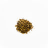 A small mound of dried saw palmetto berries, featuring a coarse, granular texture with a blend of dark brown, tan, and yellowish-gold fragments, staged on a clean white background.
