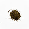 A small, centered mound of dried valerian root pieces, consisting of coarse, irregular granules in deep earthy brown and olive-tan tones, placed on a clean white background.
