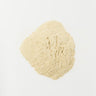 A 28g mound of finely ground, pale beige ashwagandha root powder centered on a solid white surface.