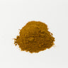 A small, vibrant mound of fine-textured, reddish-orange cayenne pepper powder centered on a plain white surface.