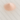 A small, peaked mound of finely ground pink Himalayan salt, showing a soft peach-pink hue and uniform crystalline texture, resting on a white marble surface with subtle grey veining.