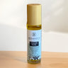 Megan & Co Ginger Rose roll-on bottle on a wooden surface with a white background
