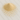 A fine, pale-yellow powder formed into a small, neat mound on a light-colored marble surface with soft grey veining.