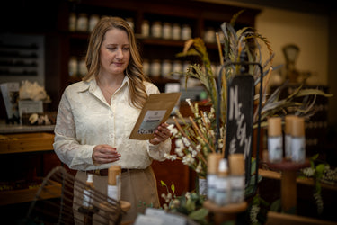 Woman in a store holding a product sample with shelves and decor in the background