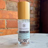 Megan & Co. Mag Mist bottle on a marble surface with a brick wall background