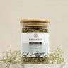 A glass jar containing loose leaf tea, with a label that reads 'Megan & Co. Nourish + Care'.
