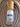A bottle of Megan & Co. Boji Bliss essential oil staged on a textured, hand-woven garment, highlighting the blend's grounding and artisan nature.