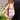 A hand holding a capped Megan & Co. Bug Ban spritzer bottle near a person's legs, featuring black pants and a lush, blurred green garden background.
