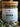 Megan & Co. Chest Re-Leaf tea in a glass apothecary jar with a bamboo lid, surrounded by eucalyptus leaves at the bottom with a soft, blurry background.