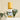 Purify room and body spritzer in a clear bottle with a wooden cap, staged on layered white marble with a fresh eucalyptus stem in the background.