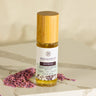 Megan & Co. Refresh Essence Spritzer with a bamboo cap standing on white marble, surrounded by dried purple lavender buds at the base.