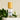 Megan & Co. Sacred Bloom Essence Spritzer with a bamboo cap on layered white marble stones with fresh green leaves at the base.