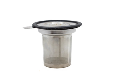 A side-profile view of a cylindrical stainless steel tea infuser basket with a fine mesh body. The top of the infuser features a wide rim capped with a flat metal lid, which is encircled by a black silicone ring and has a small metal pull-tab extending to the left.