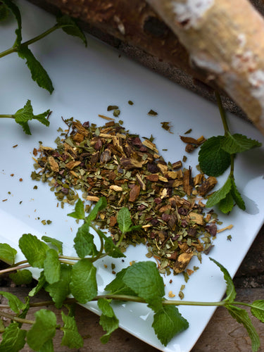 Herbs on a white plate with a wooden surface