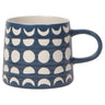 A side profile of a 12 oz navy blue stoneware mug decorated with a white, debossed celestial pattern featuring rows of crescent and full moons, shown without its stainless steel strainer.
