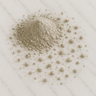 A 28g mound of fine, light gray bentonite clay powder scattered across a white marble surface.