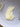 A thick swatch of pale yellow herbal nursing cream on a white textured plate with baby's breath flowers.