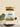 A glass jar containing dried herbal tea leaves with a label that reads 'Peaceful Prairie Tea Blend'. The jar is placed on a neutral background alongside some green foliage.