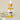 A small bottle of Happy Ear Herbal Oil with a dropper, placed on a soft surface alongside decorative flowers.