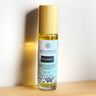 Megan & Co. Prosperity roll-on bottle on a wooden surface with a white background