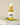 A small clear glass bottle with a dropper filled with yellow liquid, labeled 'Megan and Co R + R Herbal Oil', displayed on a white textured surface with a green leaf beside it.