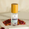 Megan & Co. Rose Facial Toner with a bamboo cap on a white marble slab with dried red rose petals at the base.