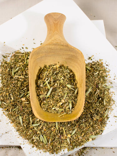 MEGAN & CO. Slumber Loose Leaf Tea Blend is presented in wooden scoop on white marble counter.