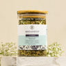 A glass jar containing loose leaf sleep aid herbal tea blend, labeled 'MEGAN & CO: Slumber.  