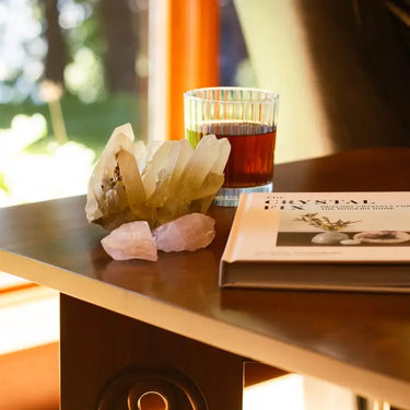 Crystal setup with a glass of liquid on a table, featuring a book titled 'Crystal Fix'.