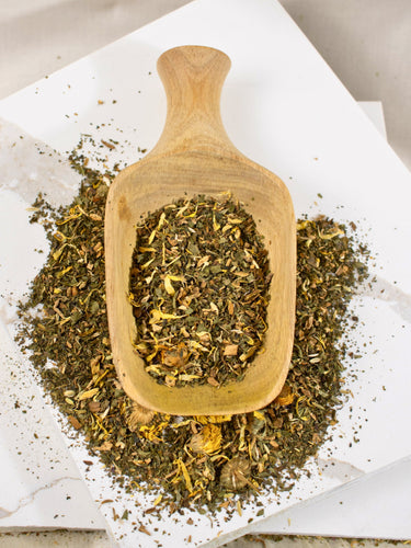 MEGAN & CO. Tummy Time Loose Leaf Tea Blend is presented in wooden scoop on white marble counter